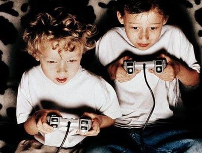 Two boys playing video games on a cowhide rug with their PlayStation.